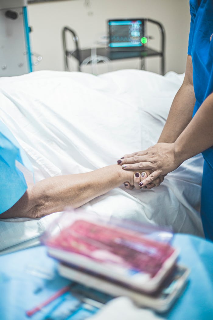A nurse provides care and comfort to a patient resting in a hospital bed.